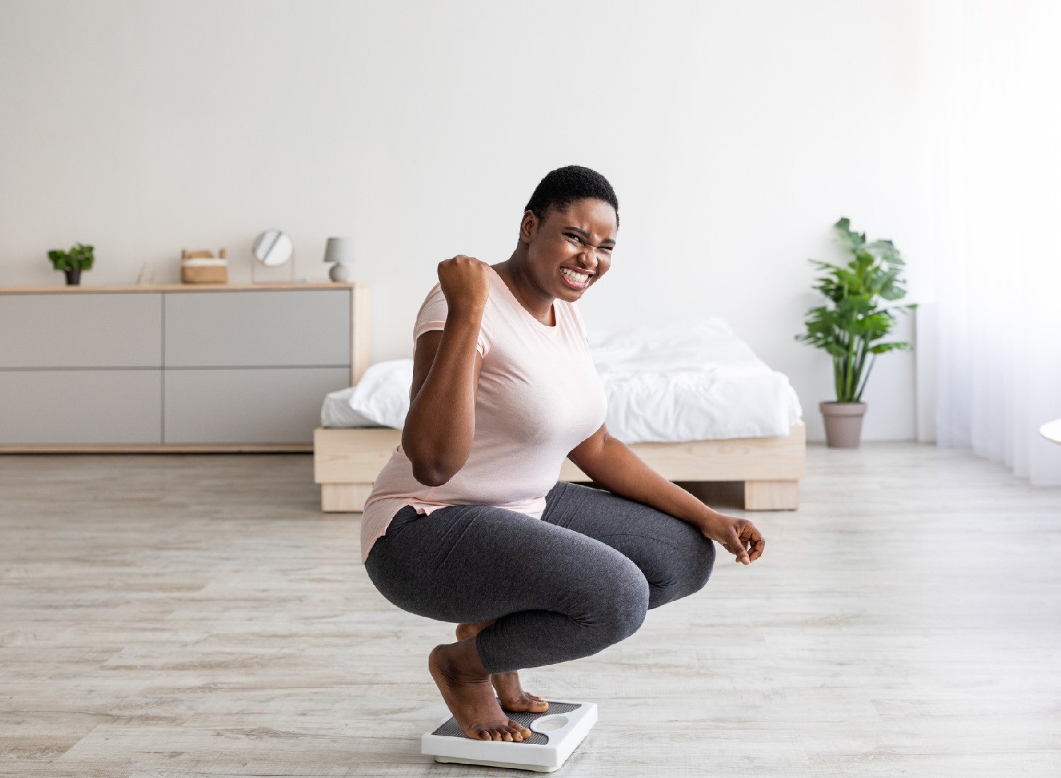 Overjoyed plus size African American lady achieving her weight loss goal