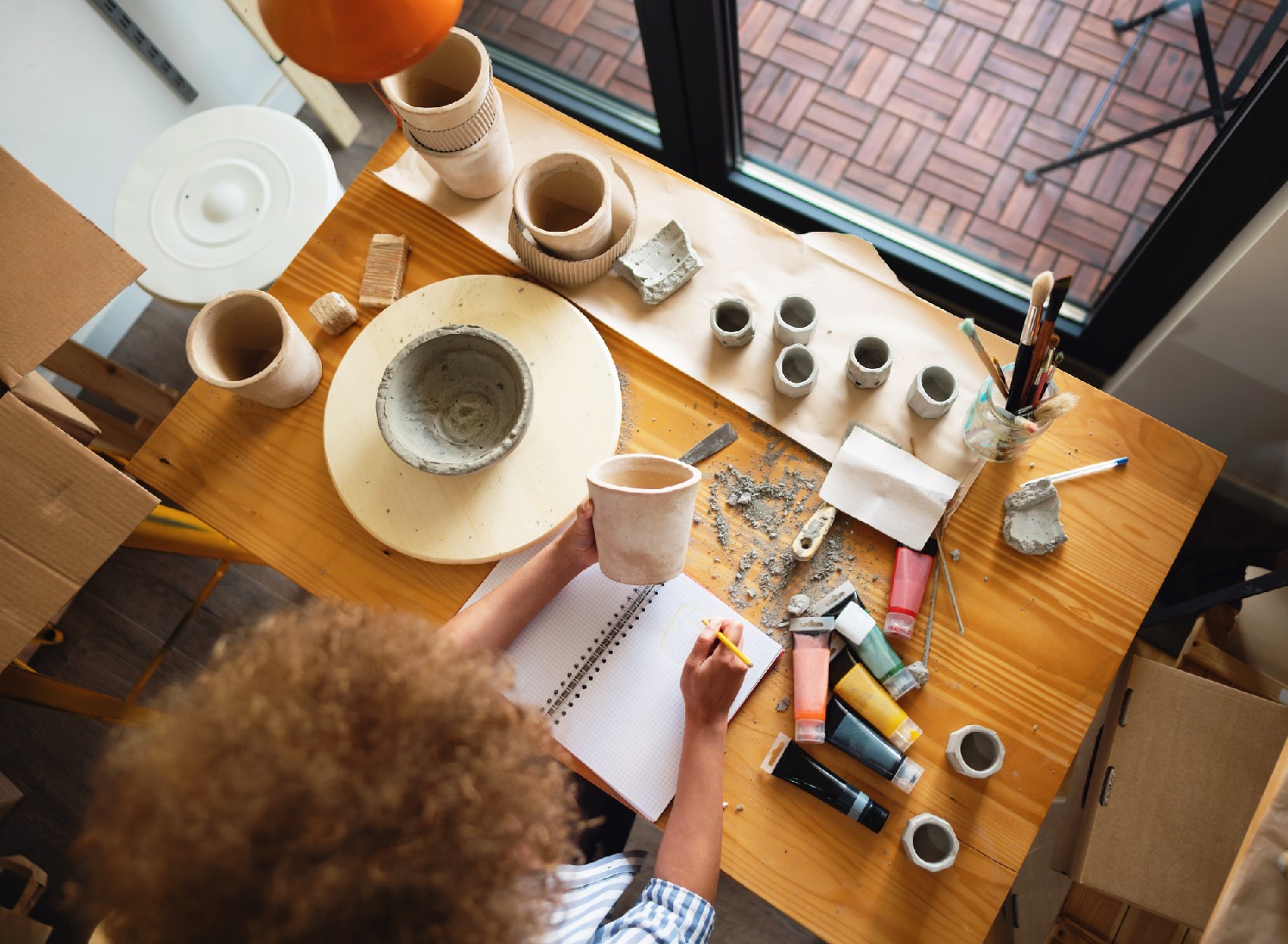 High angle view of an unrecognizable woman working at her desk in a pottery studio