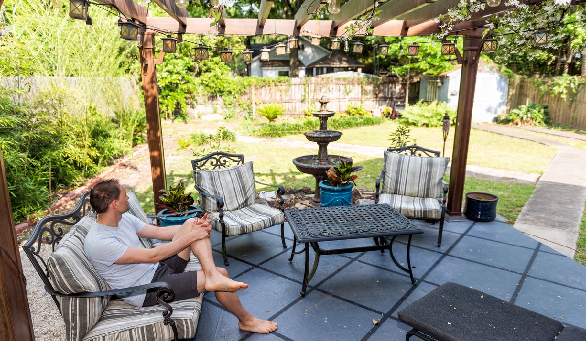 Young man sitting on pergola canopy