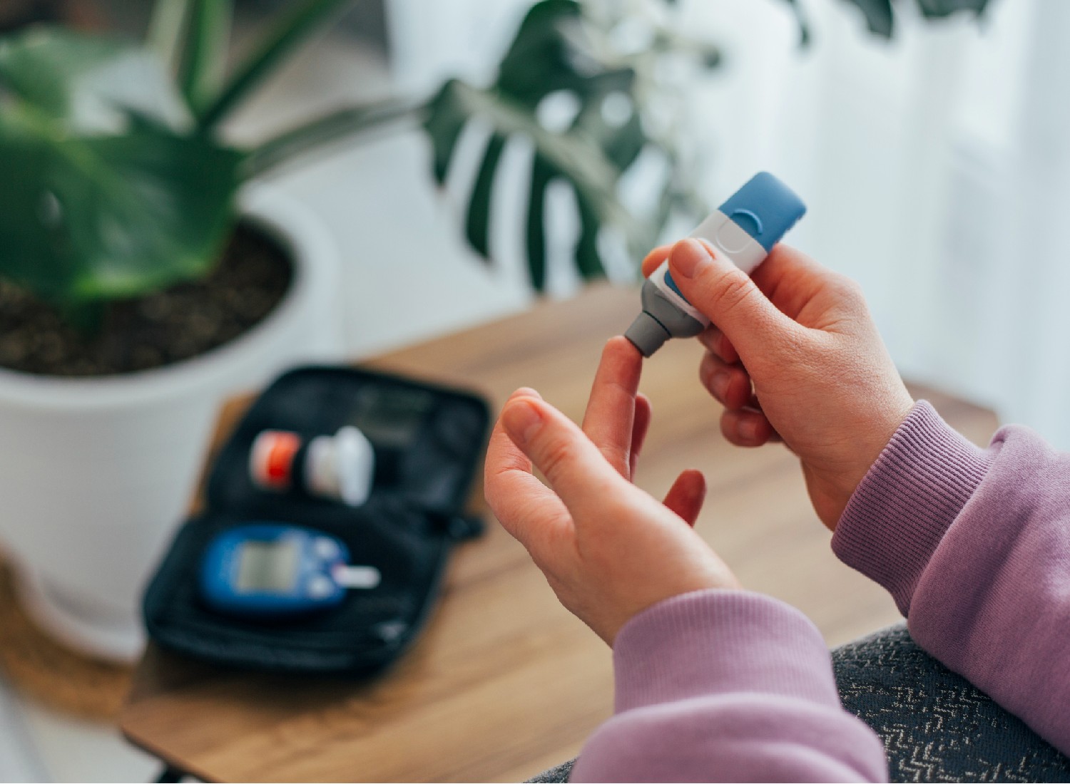 Woman doing blood sugar test at home, close up