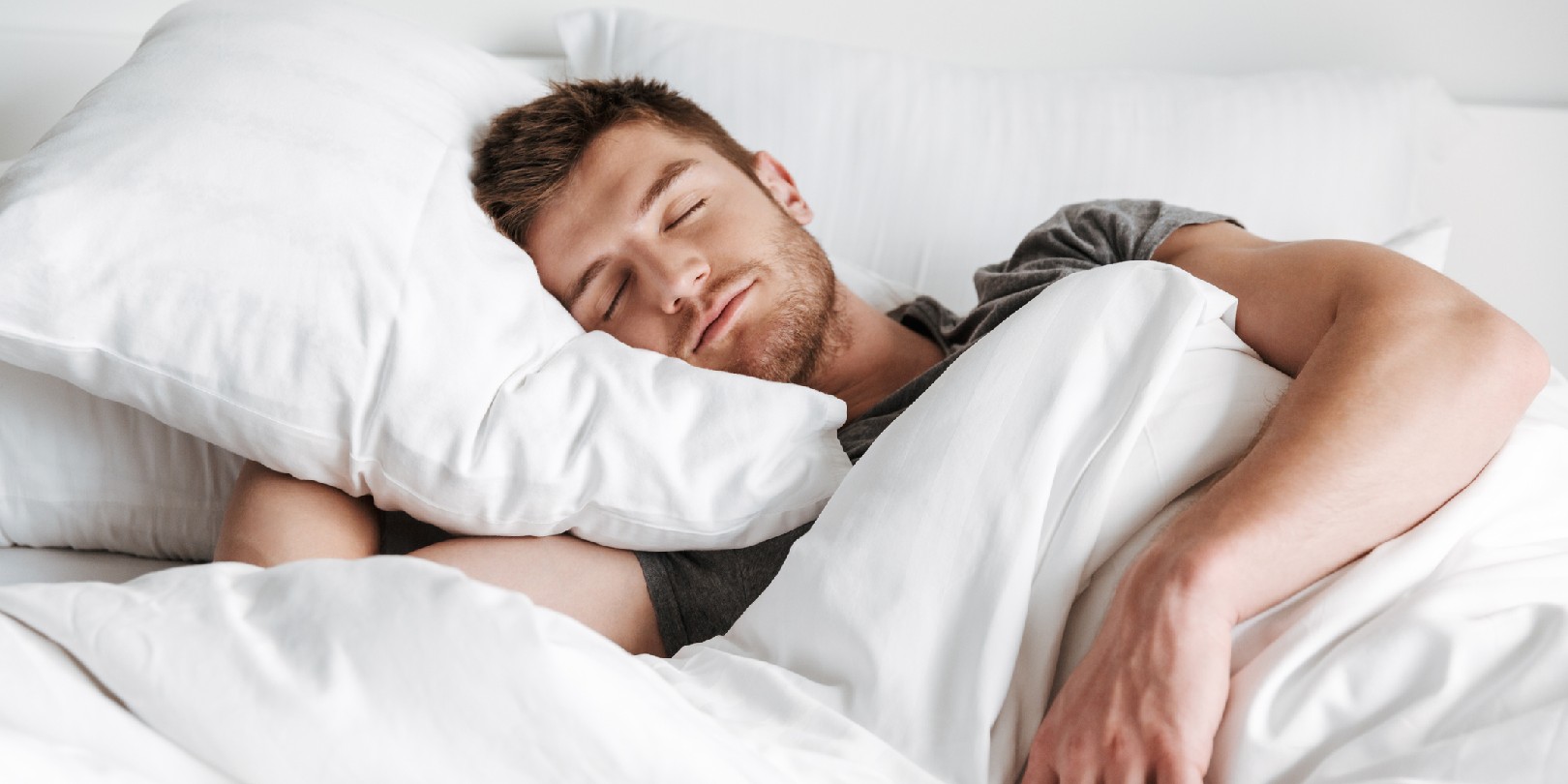 Handsome young man sleeping in bed