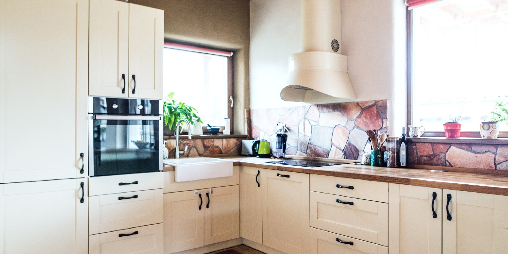 An oven, sink, cooker and cabinets in the kitchen.