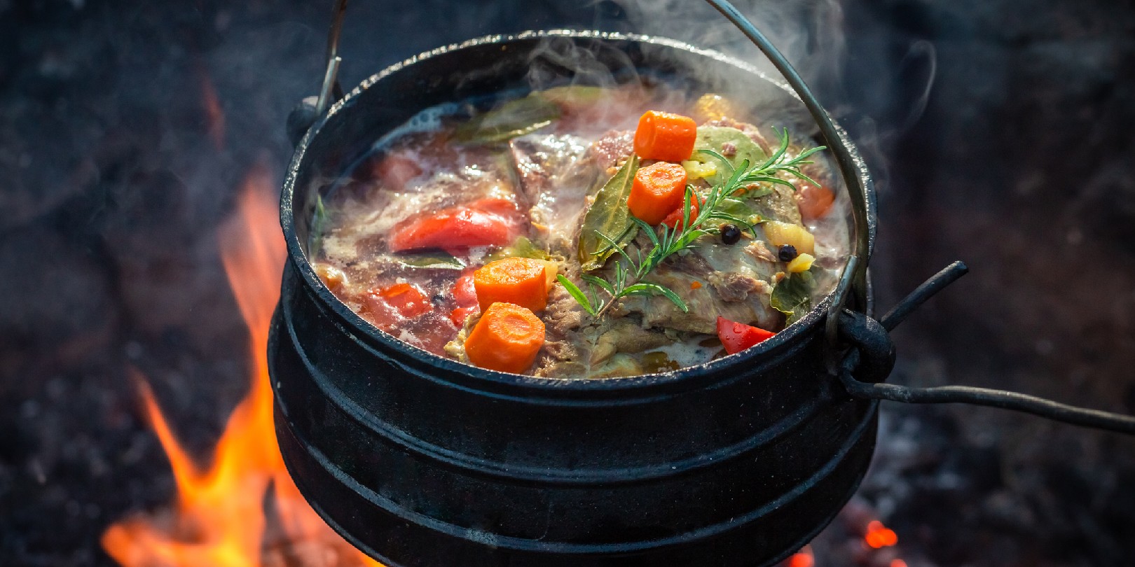 Tasty and spicy hunter's stew on bonfire