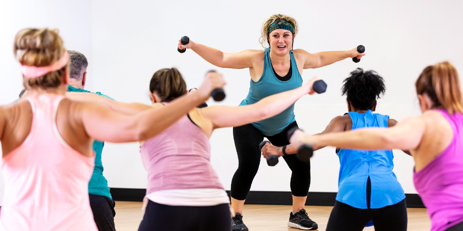 Hispanic woman leading aerobics class