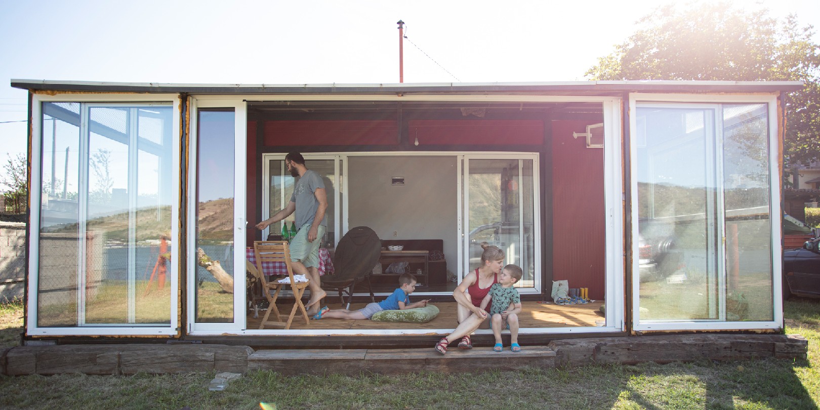 Family with two children and a dog enjoying in their container house.