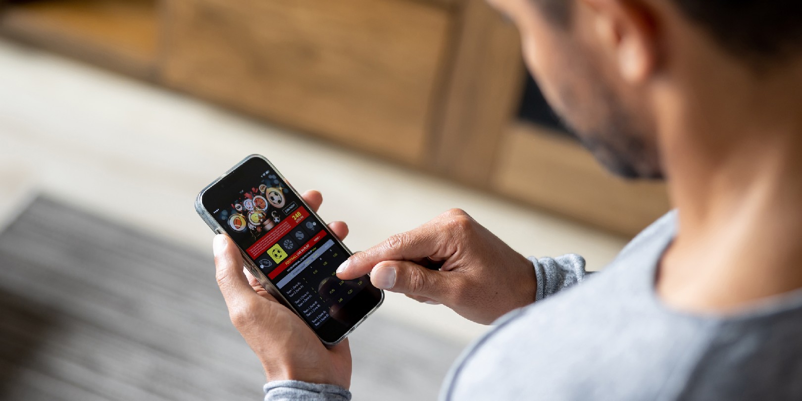 Man gambling online on a football match using his cell phone - lifestyle concepts